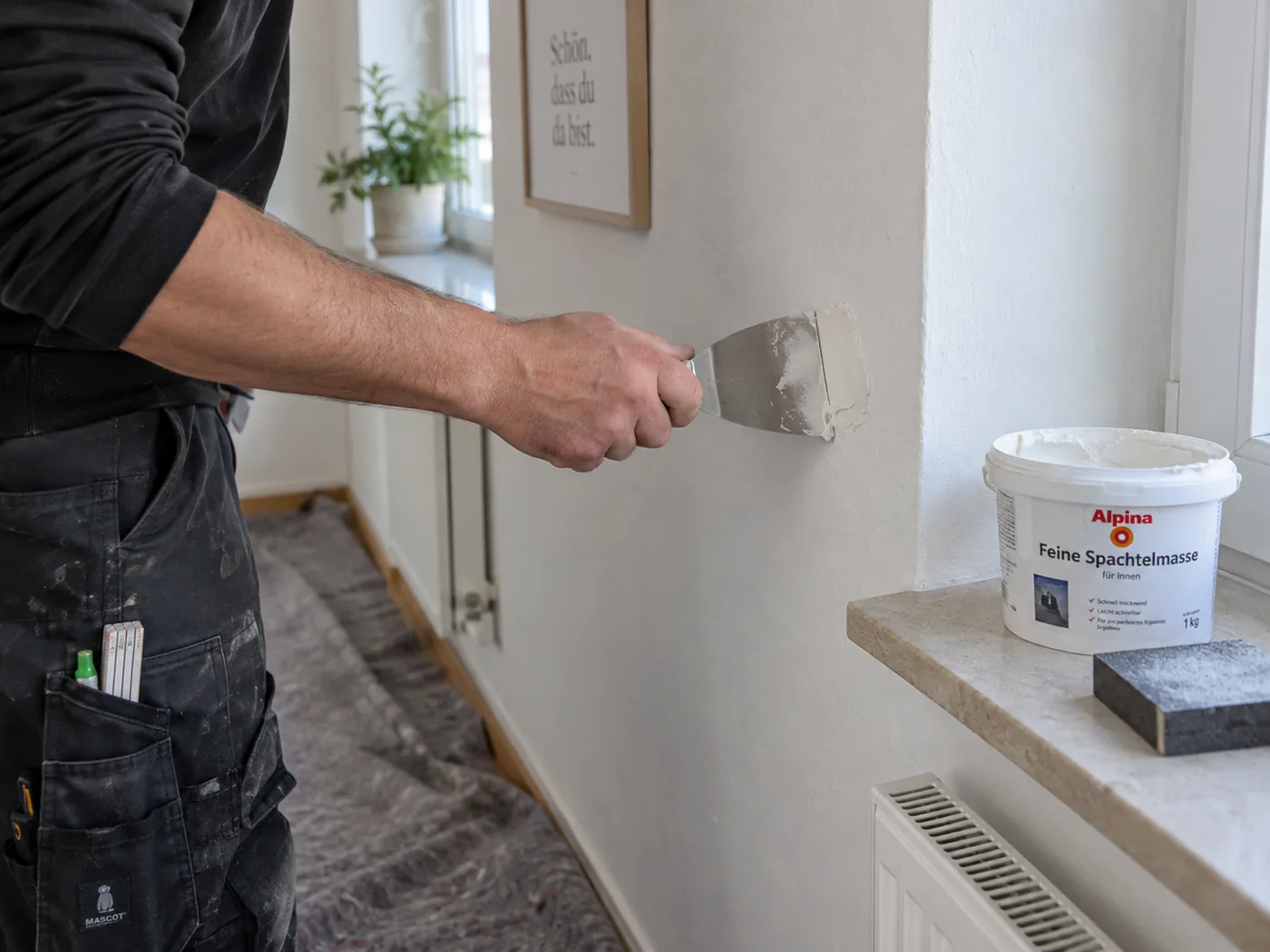 Malerarbeiten in Leonberg: Handwerker spachtelt Dübellöcher vor dem Streichen